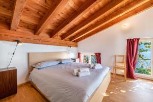 ein Schlafzimmer mit einem großen Bett in einem Zimmer mit Holzdecken in der Unterkunft Appartamento molini in casa Daria in Gargnano