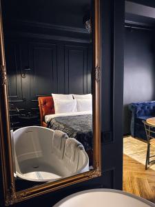 a mirror with a bath tub in a room with a bed at Central Gate apartment in Chernivtsi