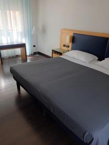 Luxury Rooms Padova Station في بادوفا: غرفة نوم بسرير كبير وطاولة
