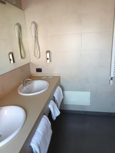 a bathroom with two sinks and a shower and a tub at Luxury Rooms Padova Station in Padova