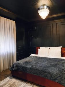 a bedroom with a bed and a chandelier at Central Gate apartment in Chernivtsi