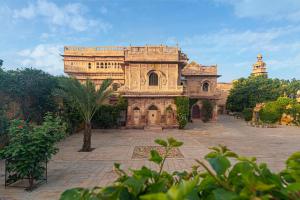 an old building with a palm tree in front of it at WelcomHeritage Mandir Palace in Jaisalmer