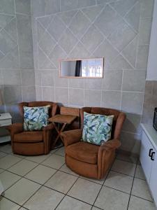 a room with two chairs and a table and a mirror at 38 Park Avenue, Desainger, Tongaat in Densainagar