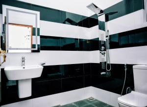 a black and white bathroom with a sink and a shower at Aurum Boutique in Negombo