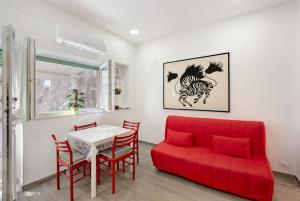 un soggiorno con divano rosso e tavolo di Holiday House - Arenzanohost ad Arenzano