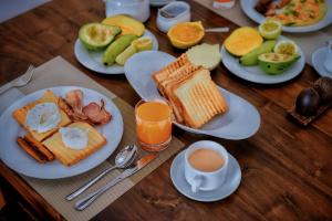 a wooden table with plates of breakfast foods and a cup of coffee at Aurum Boutique in Negombo