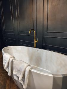 a white bath tub with two towels in a bathroom at Central Gate apartment in Chernivtsi
