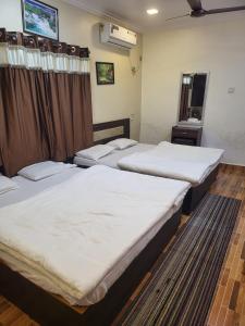 a group of three beds in a room at Kokan Safari, Chiveli in Bhom