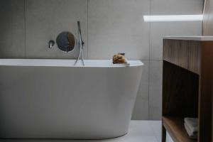 a white bath tub in a bathroom with a mirror at Jabłonki Resort&Spa in Jabłonki