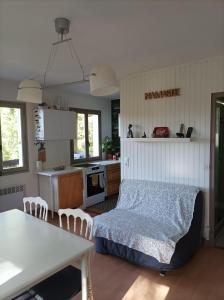 a bedroom with a bed and a kitchen with a table at Chambre privée dans chalet au calme in Saint-Brisson