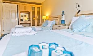 two beds in a room with a lighthouse in the background at Watermark Apartments in Whitby