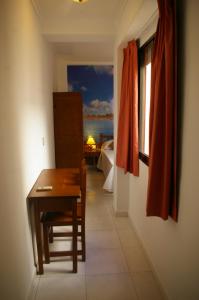 Habitación con escritorio, mesa y ventana. en Habitaciones Trovador en Puerto de Sagunto