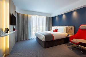 Pokój hotelowy z łóżkiem i czerwonym krzesłem w obiekcie Holiday Inn Express Bridgwater M5, Jct24, an IHG Hotel w mieście Bridgwater