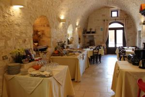 a dining room with tables with white table cloth at Masseria Valente in Ostuni