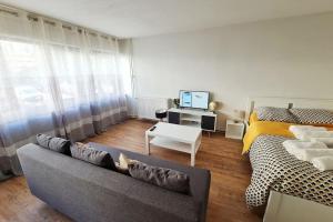 a living room with a couch and a bed at L'Alex Solj-Studio spacieux en résidence avec parking privée - Easy check-in - Arrivée autonome in Évry-les-Châteaux