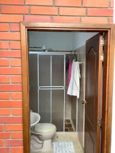 a bathroom with a toilet in a brick wall at San Gil beautiful house in San Gil