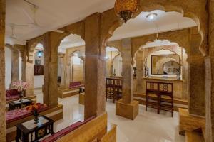 a salon at a hotel with columns and mirrors at WelcomHeritage Mandir Palace in Jaisalmer