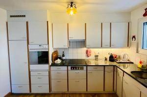 eine Küche mit weißen Schränken und einer Spüle in der Unterkunft Sankt Moritz Chesa Ruinatsch 50 in St. Moritz + 16 Fotos