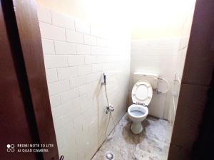 a bathroom stall with a toilet with a hose at Beach/US Russian Consulate/Kitchen/Unlimited Super Fast Wifi in Chennai