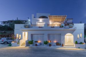 ein weißes Haus mit einem Solarium darüber in der Unterkunft Aegean Suites in Votsi