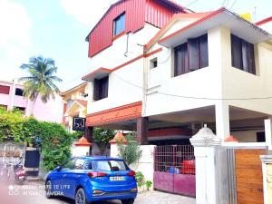 a blue car parked in front of a building at Beach/US Russian Consulate/Kitchen/Unlimited Super Fast Wifi in Chennai