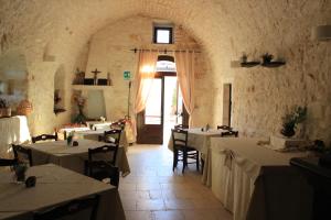 a dining room with tables and chairs and a window at Masseria Valente in Ostuni