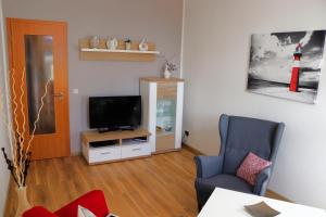 a living room with a television and a chair at Anna-App-10 in Ahlbeck