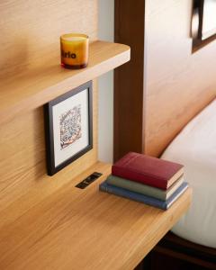 a stack of books on a shelf next to a bed at Arlo SoHo in New York