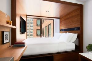 a bedroom with a large bed with a window at Arlo SoHo in New York