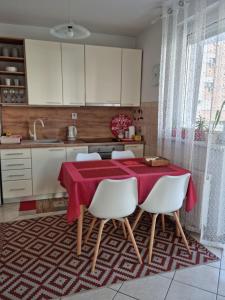 a kitchen with a table with a red table cloth on it at Stan na dan "Irina" Banja Luka in Banja Luka