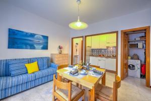 uma sala de estar com uma mesa e um sofá azul em Il Tulipano Giallo 100 Mt From The Sea - Happy Rentals em San Bartolomeo al Mare