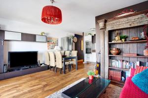 a living room with a television and a dining room at Precioso Piso cerca de la Playa in Costa Teguise