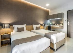 une chambre d'hôtel avec deux lits et une cuisine dans l'établissement Nap In Fest, à Chiang Mai