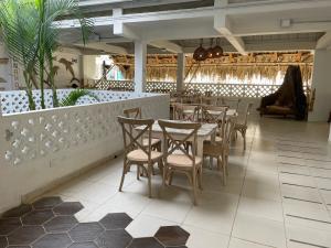 um restaurante com uma mesa e cadeiras num quarto em El Faro Hostel em Arboletes