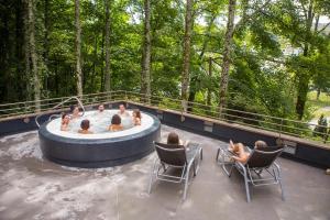 un grupo de personas sentadas en una bañera de hidromasaje en una terraza en Appartemment situé a lacaune les bains, en Lacaune