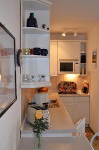 eine Küche mit weißen Schränken und einer Arbeitsplatte in der Unterkunft Miramar App. 08 in Ahlbeck