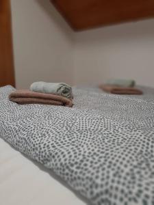 - un lit avec une couverture et une serviette dans l'établissement Portum vendégház, à Siófok