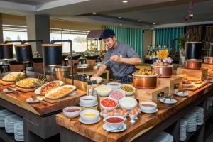 a man is preparing food in a restaurant kitchen at Radisson Resort & Spa Hua Hin in Cha Am