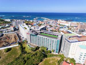 an aerial view of a city with the ocean at Ramada by Wyndham Jeju Hamdeok in Jeju