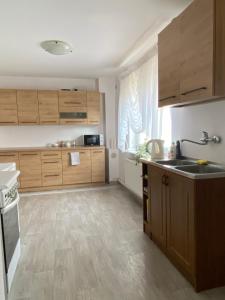 a kitchen with wooden cabinets and a sink and a stove at Dom Na Zachodzie in Szczecinek