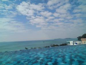 a swimming pool with a view of the ocean at Grandbeach1 Condo A203 in Ban Tha Fat