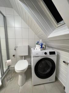 Un baño con lavadora y un inodoro. en Wohlfühl Loft - Seenähe, Boxspringbett, Küche, en Bregenz