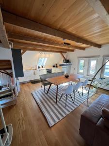 Una cocina y un comedor con mesa y sillas. en Wohlfühl Loft - Seenähe, Boxspringbett, Küche, en Bregenz