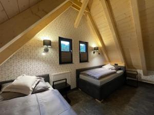 a attic room with two beds and two windows at Quartier 22 in Kurort Steinbach-Hallenberg
