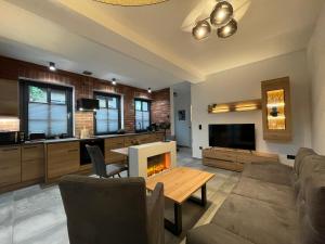 a living room with a table and a fireplace at Quartier 22 in Kurort Steinbach-Hallenberg