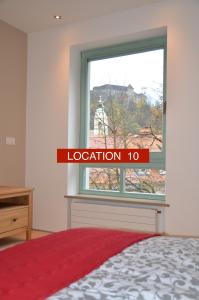 Habitación con cama y ventana con una señal roja en i Design Studio, en Liubliana