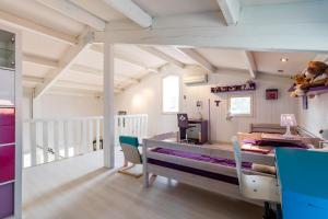 Habitación con cama, mesa y sillas. en Villa bleue, en Sanguinet