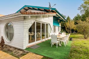 una casa de juegos con mesa y sillas en un patio en Villa bleue en Sanguinet