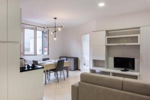Sala de estar y comedor con sofá y mesa en Santo Stefano di Magra Modern Apartments, en Santo Stefano di Magra