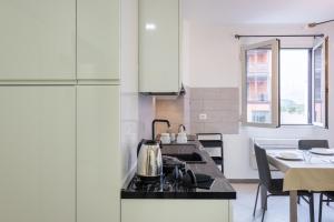 una cocina con estufa horno superior junto a una mesa en Santo Stefano di Magra Modern Apartments, en Santo Stefano di Magra 22 fotos más